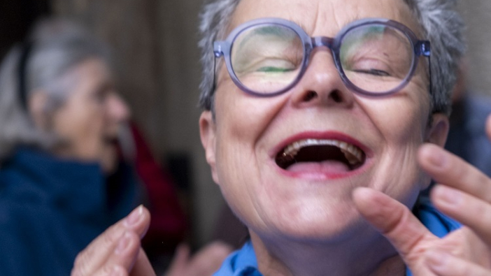 Frau mit Brille singt mit geschlossenen Augen